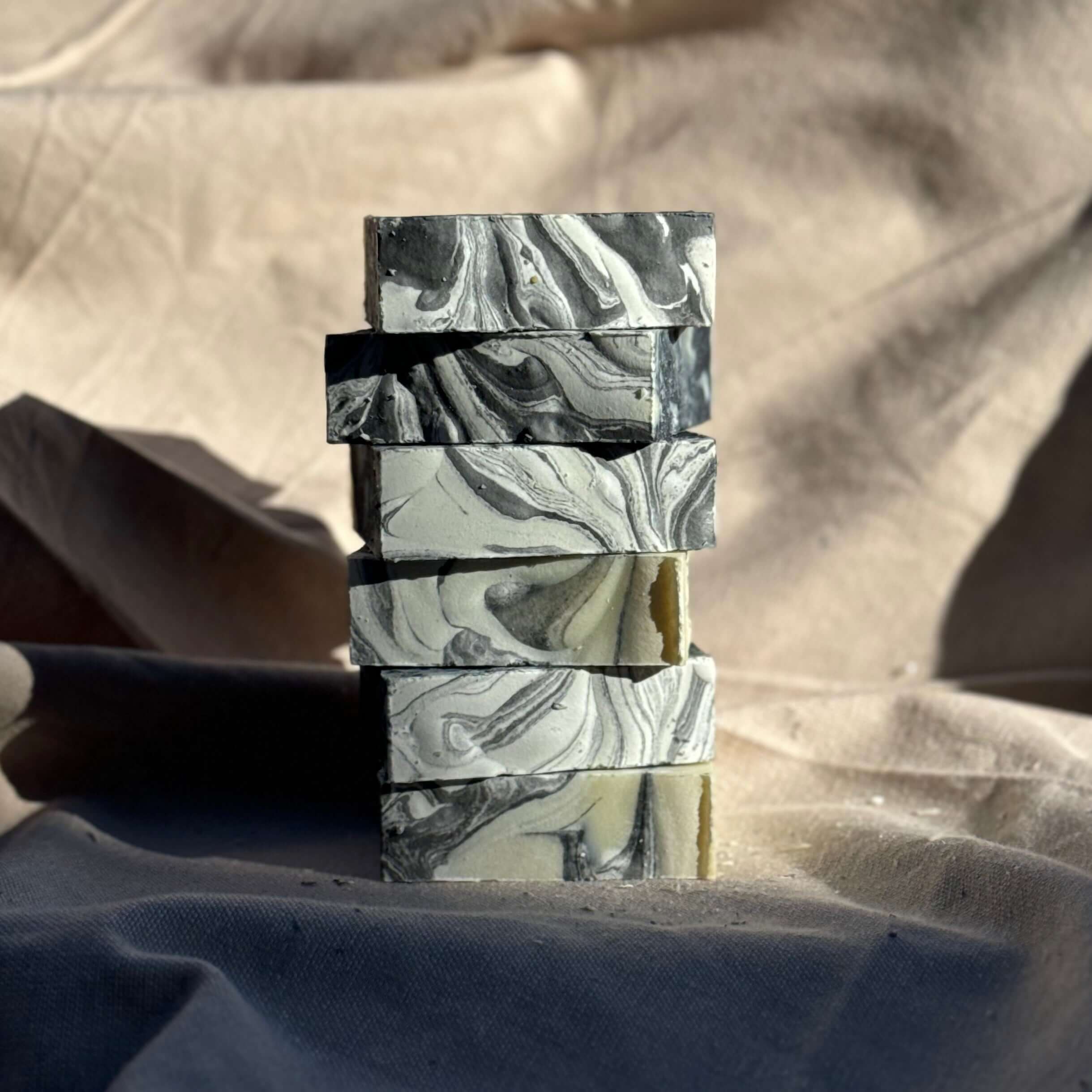 Classic Lavender Soap Bar stacked handmade charcoal swirl lavender soap bars on neutral fabric background