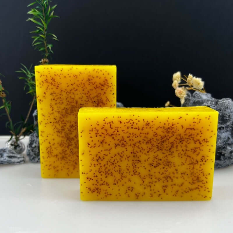kojic acid dark spot remover soap bars with vitamin C and exfoliating specks against dark background