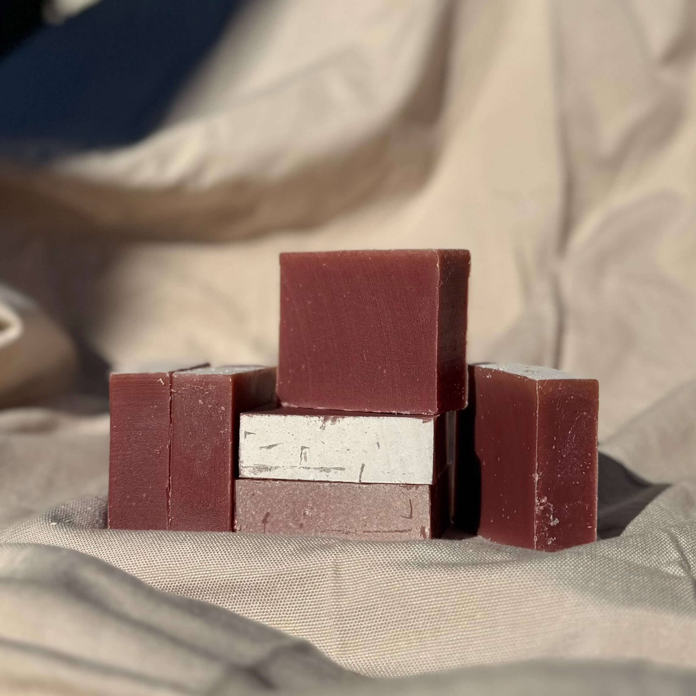 Cedar Wood & Frankincense Soap Bar with french red clay stacked on neutral fabric background