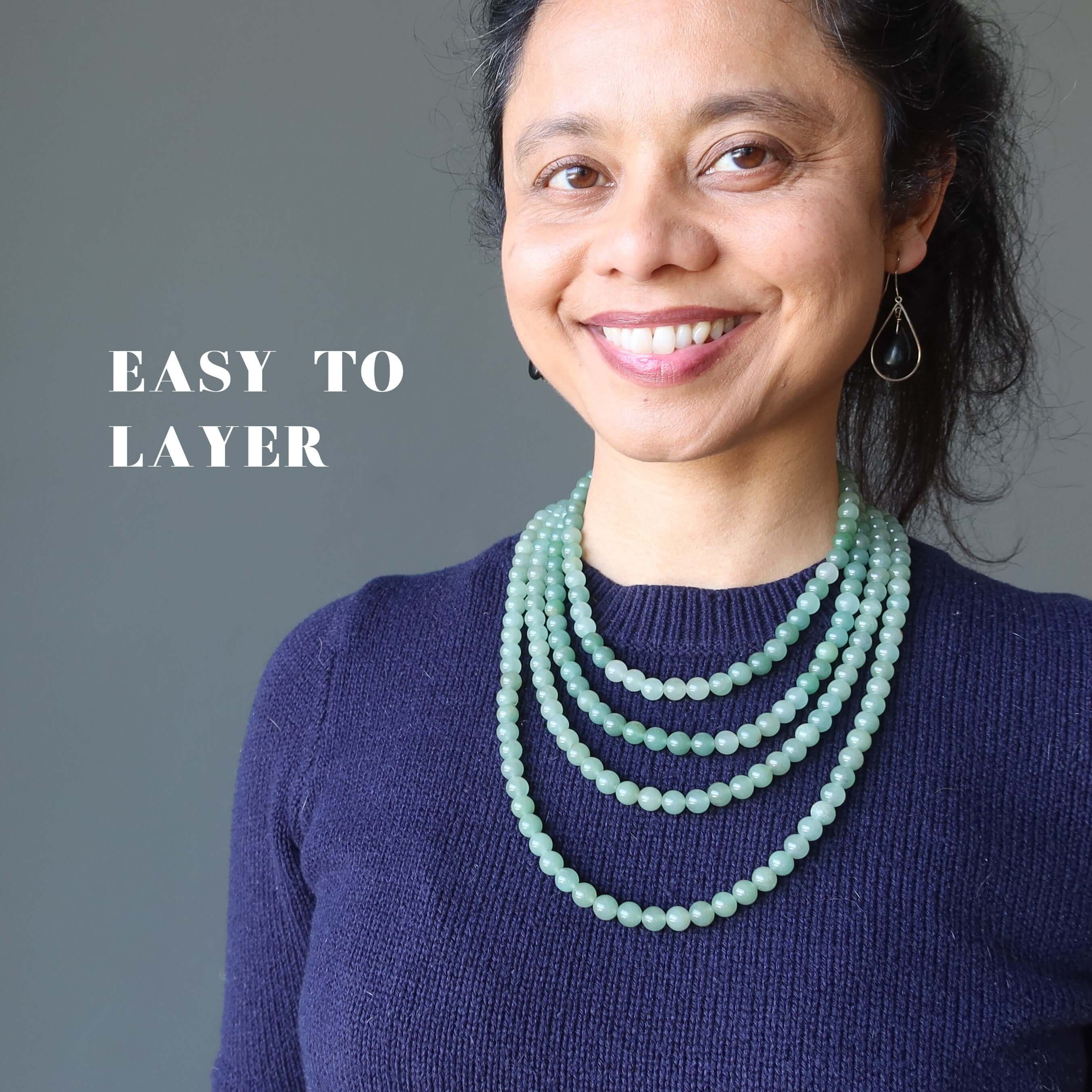 Woman smiling in layered Green aventurine necklace strands, showcasing easy to layer wealth stones jewelry