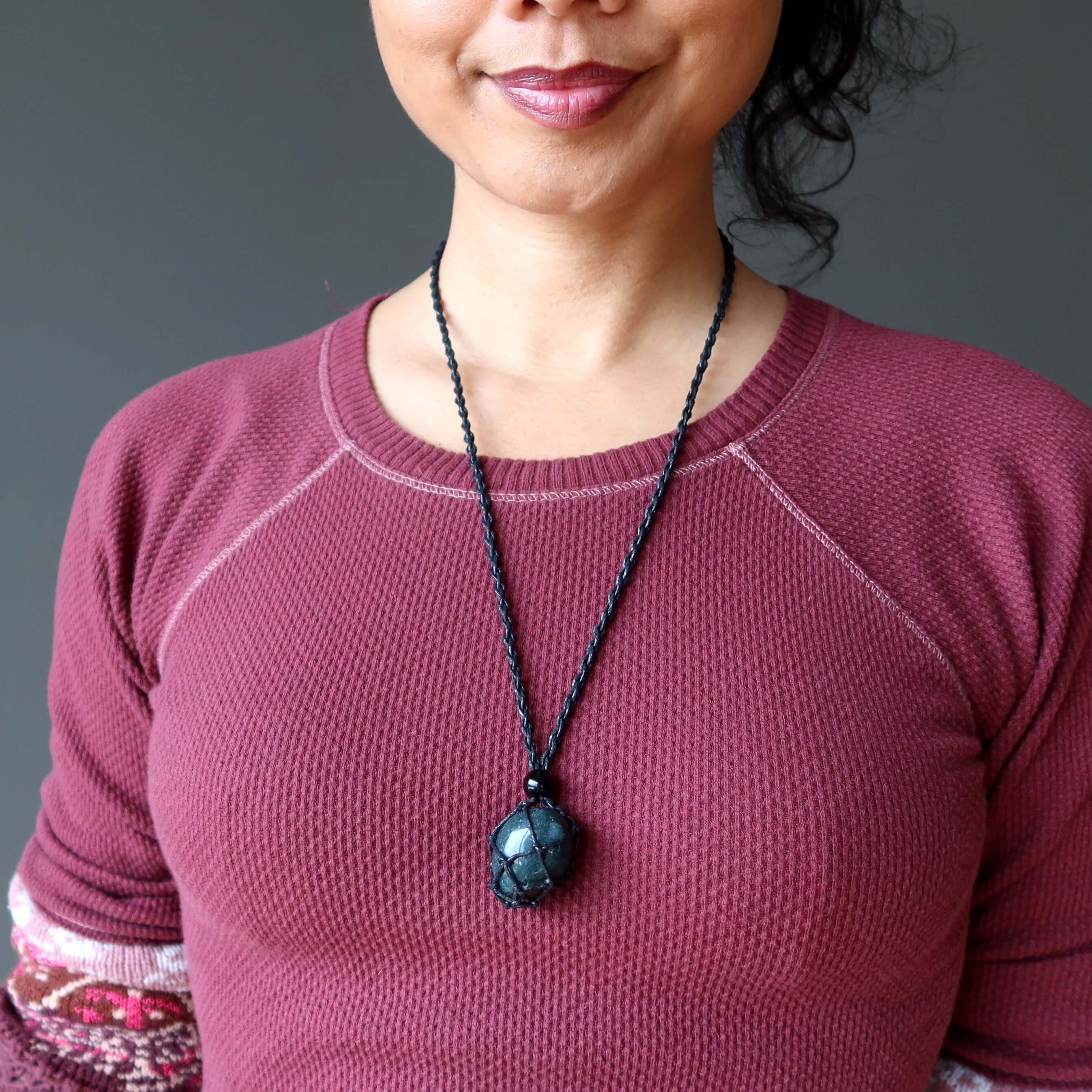 Woman wearing adjustable macrame Bloodstone necklace, courage crystal pendant resting at chest