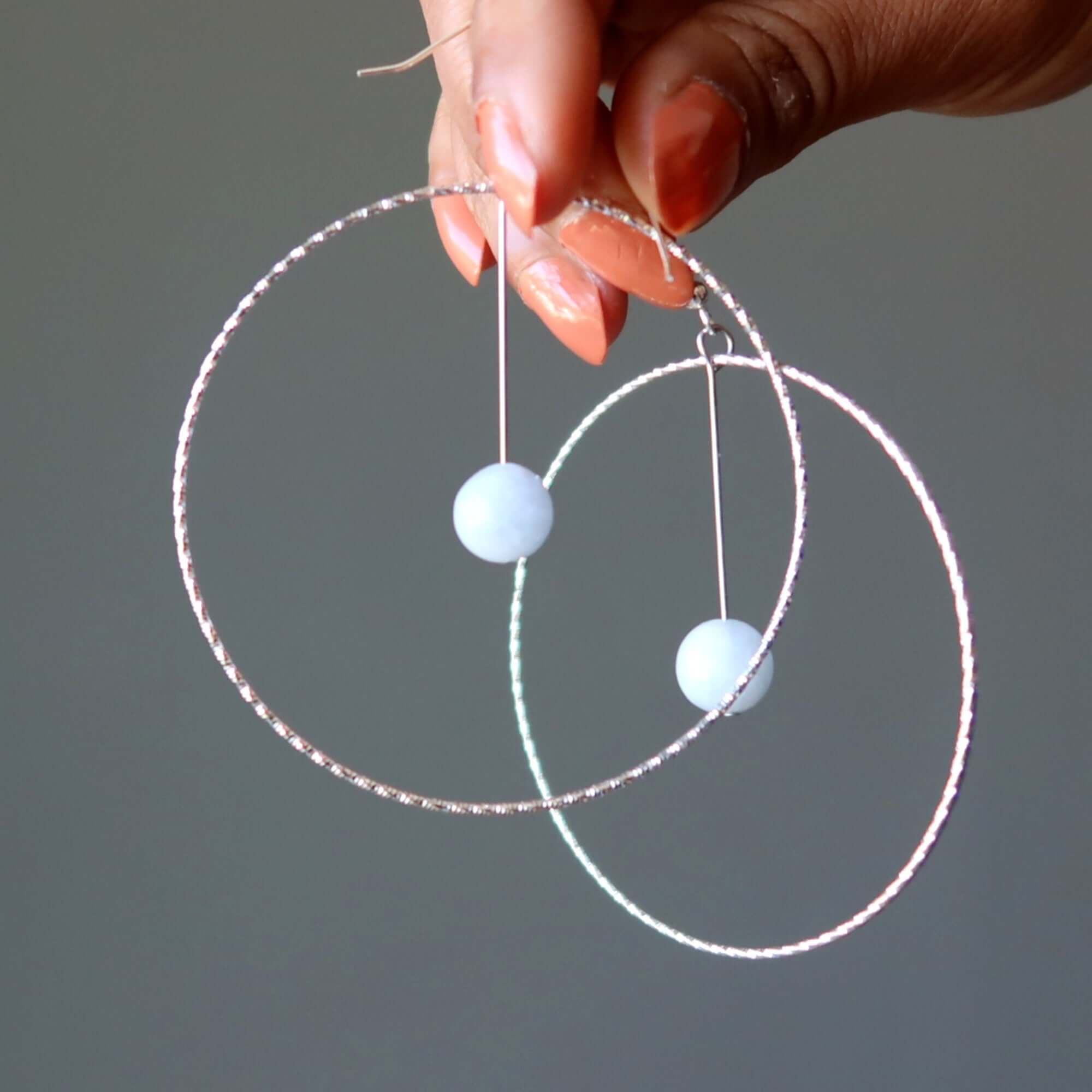 Blue Calcite earrings Heavenly Hoops of Silver, large hammered hoops with Blue stone beads held by a hand, Blue jewelry closeup