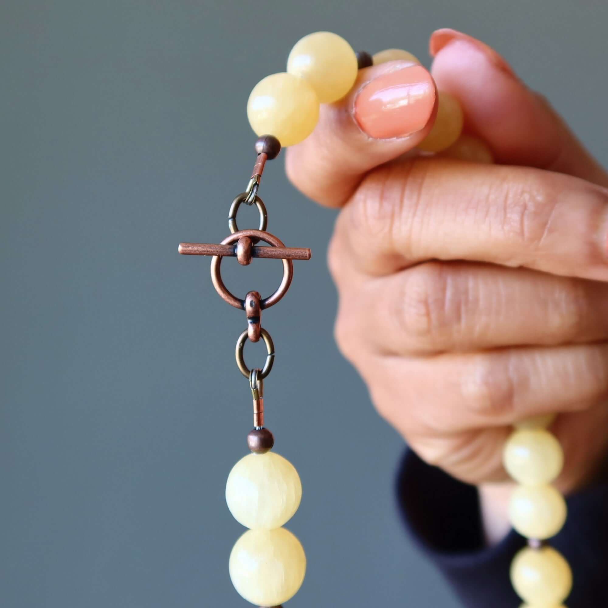 Yellow Calcite necklace with copper toggle clasp held in hand, round 11-12mm Yellow stones for bright confident jewelry style