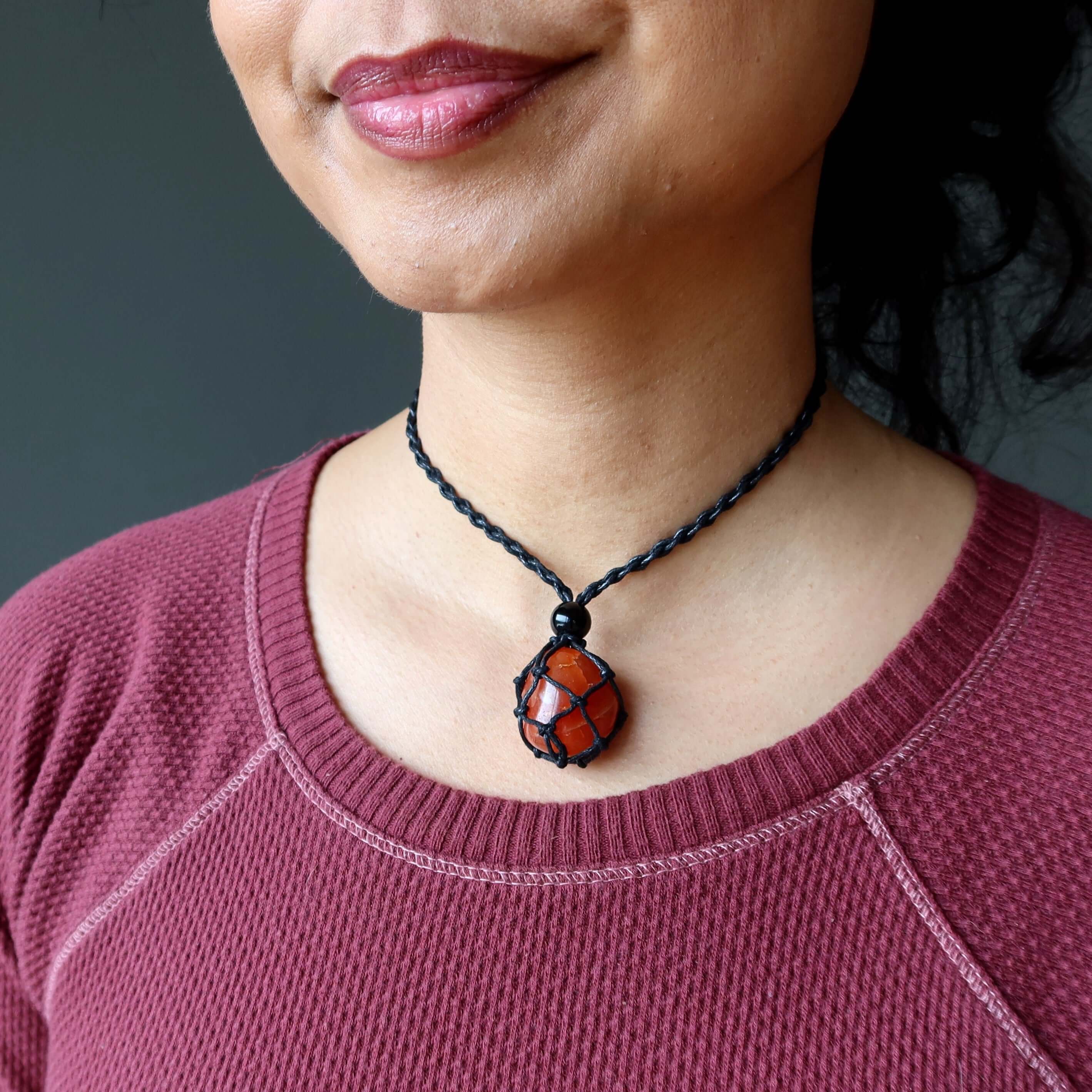 Woman wearing adjustable macrame Carnelian necklace with orange hot stone pendant close to neck