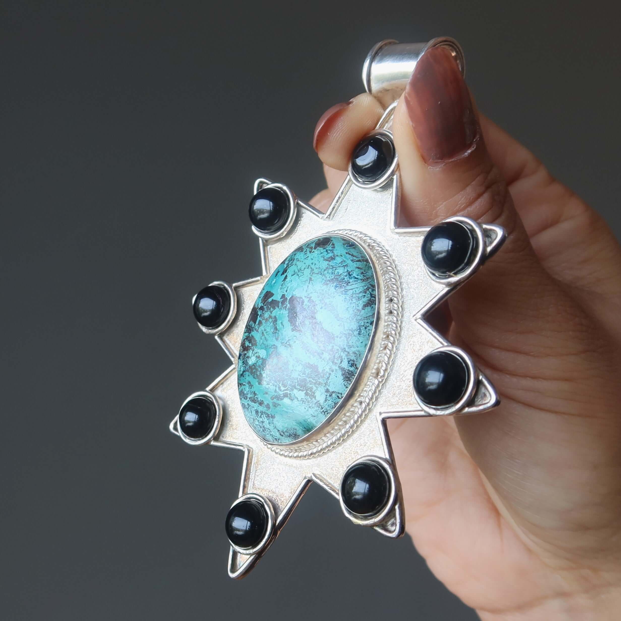 Chrysocolla sterling silver mega star pendant with large oval gemstone and black accent stones held in hand