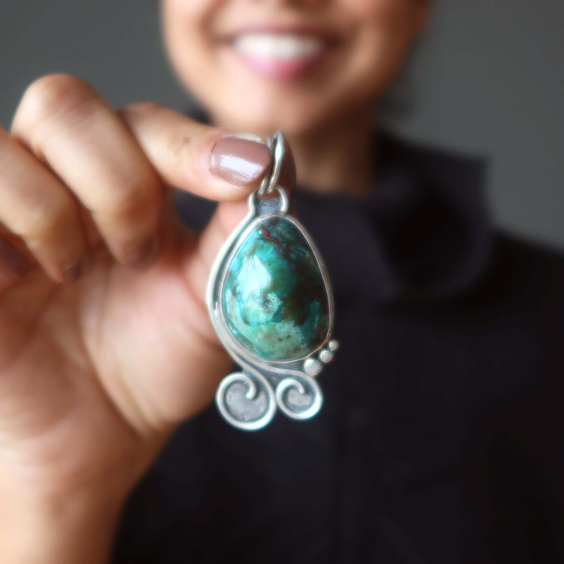 Chrysocolla pendant in sterling silver with cuprite Sonora gem held in hand close-up