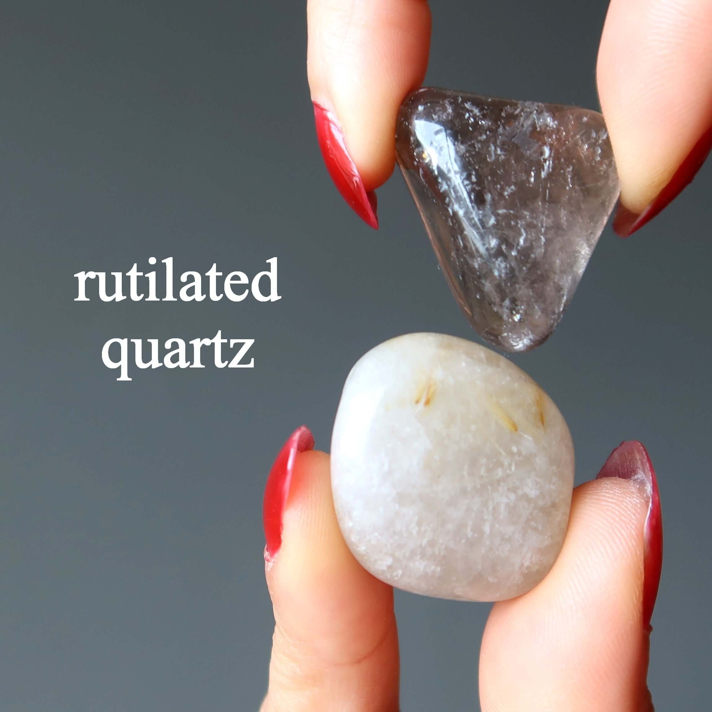 Tumbled rutilated quartz stones held between fingers, polished crystals for crown chakra healing and spiritual energy work