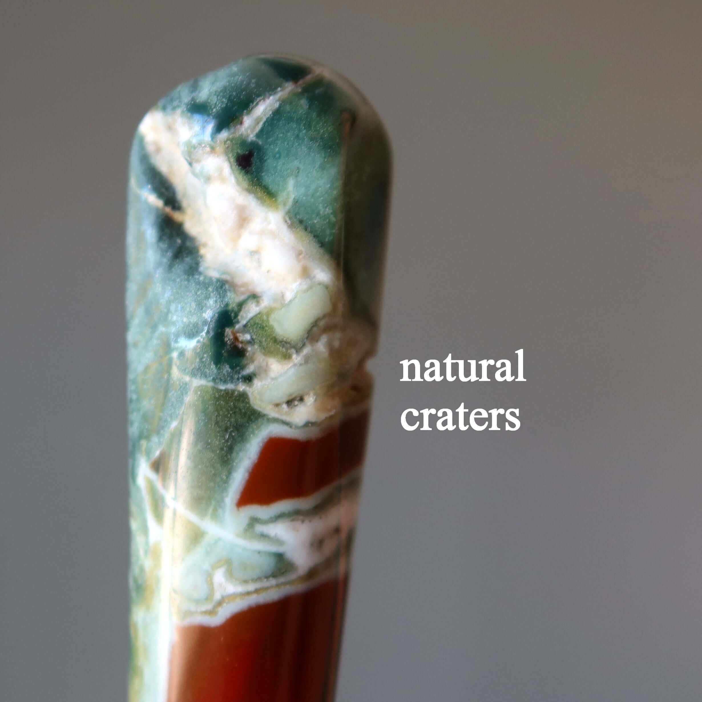 close up of Jasper jasper massage wand tip showing natural craters and multicolor earthy stone patterns