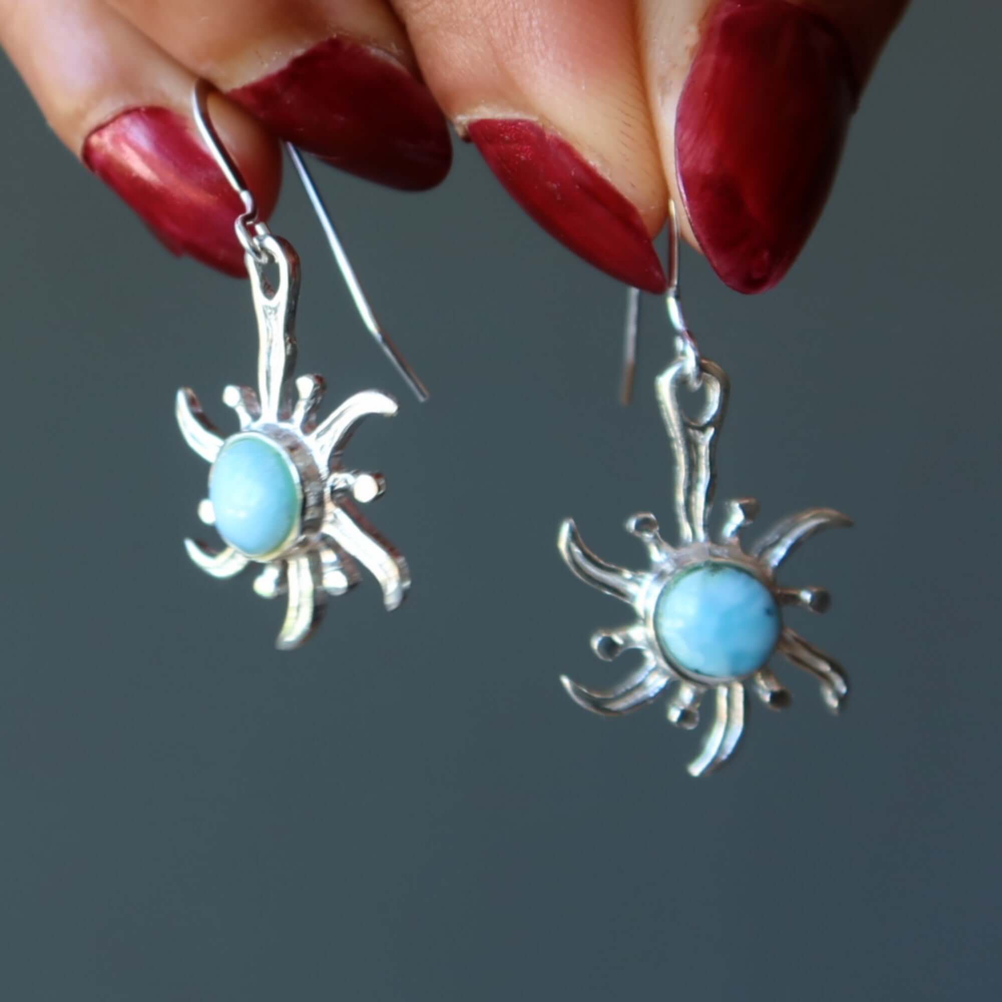 Larimar sterling silver sun earrings with blue gemstones dangling from hooks