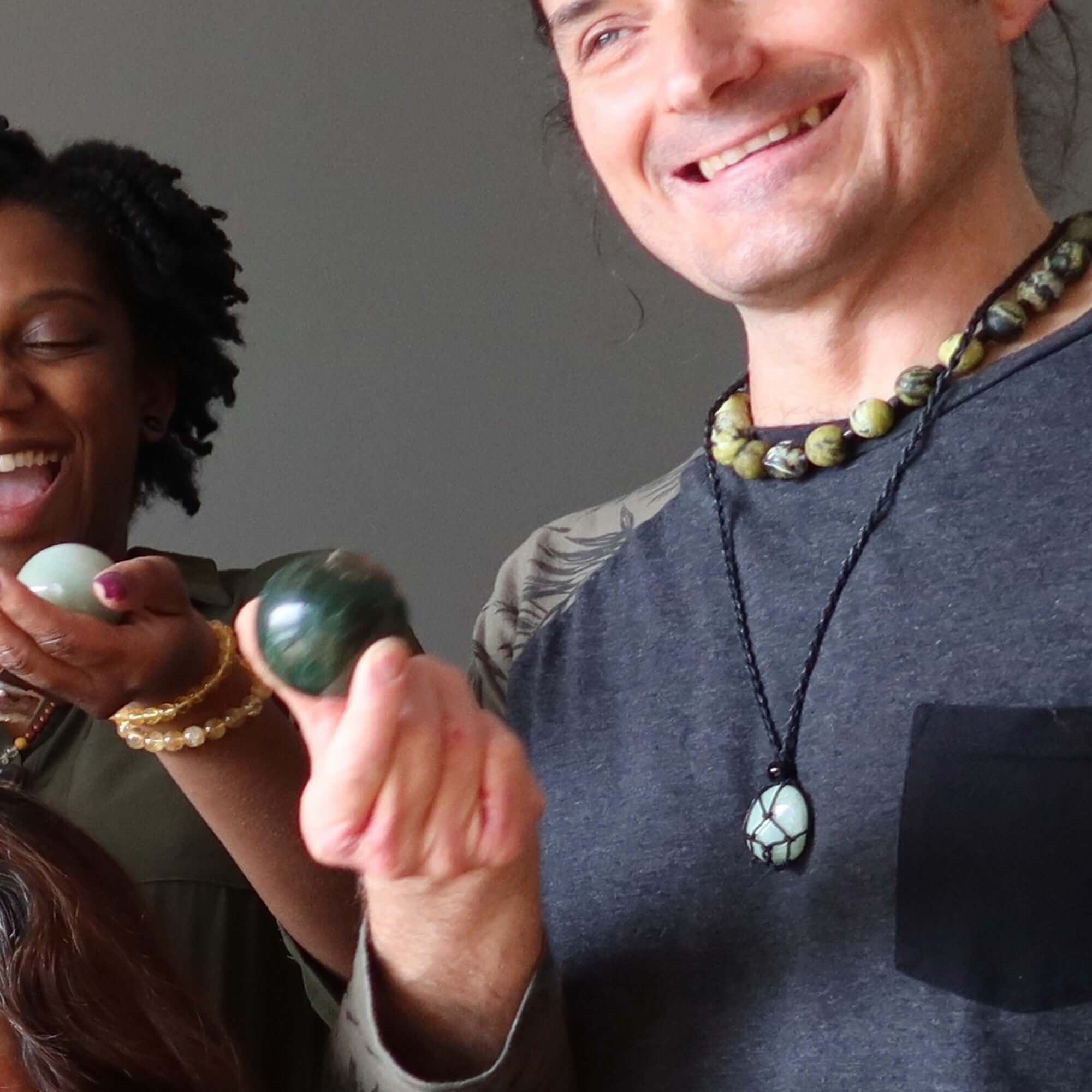 Money necklace set with citrine and green aventurine stones worn by smiling people holding crystal spheres