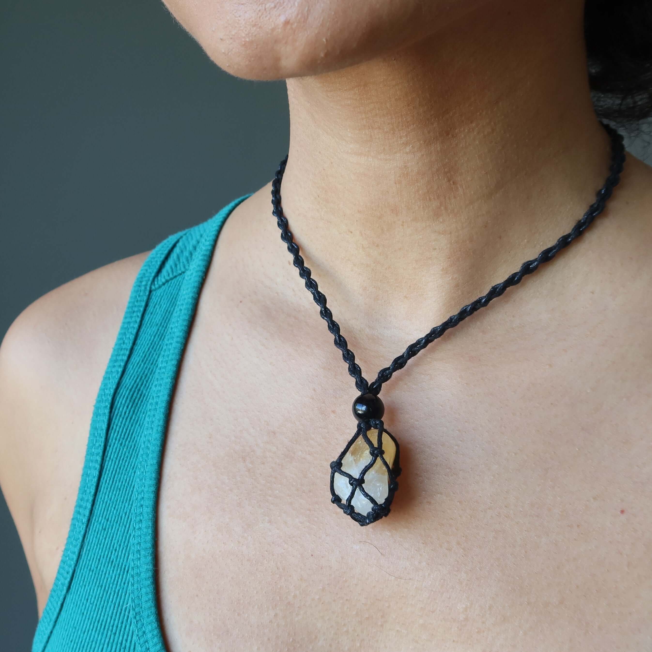 Money necklace set with citrine aventurine stone pendant in black macrame cord on model’s neck
