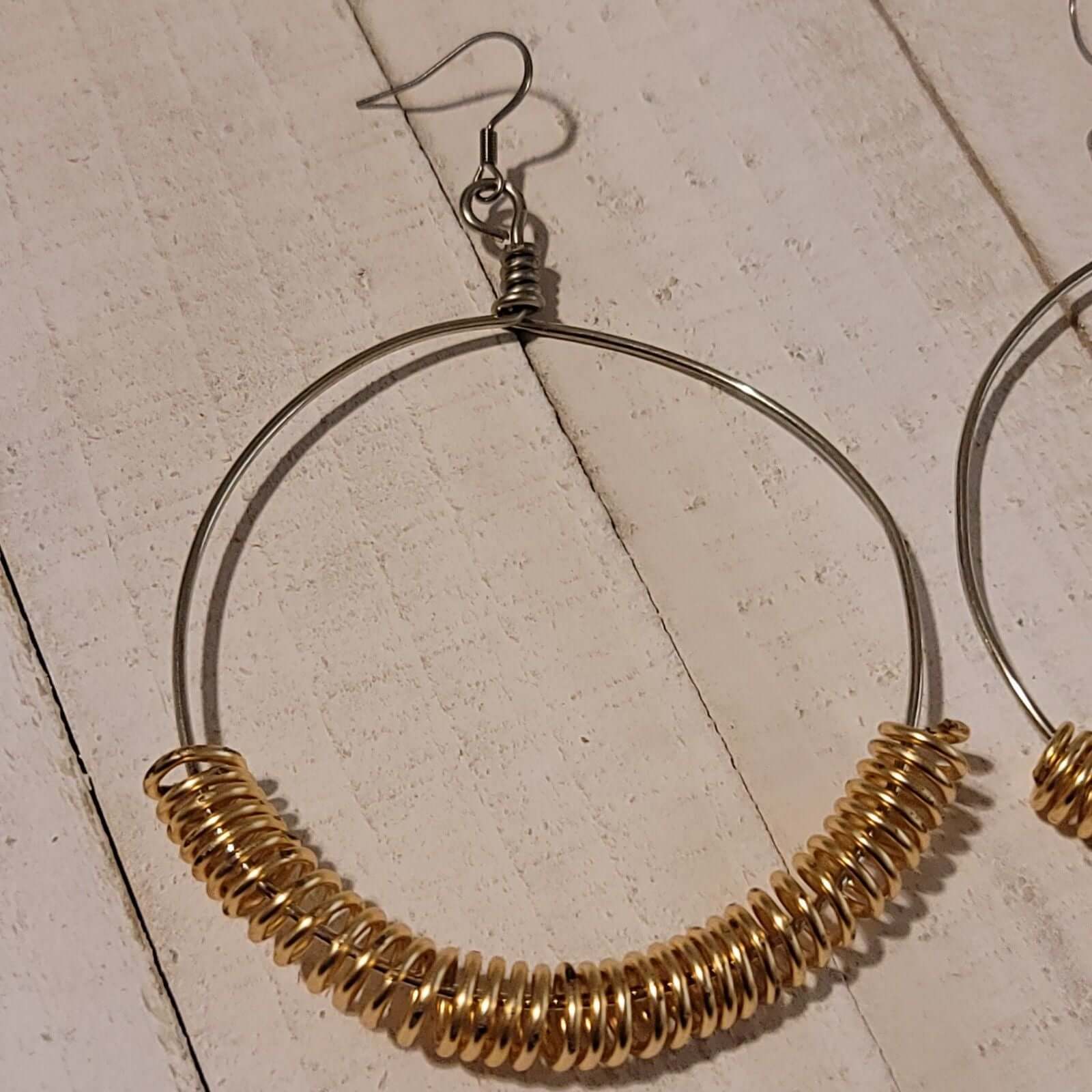 Handmade Gold Spring Hoop Earrings – Lightweight Wire Wrapped Hoops on rustic wood background