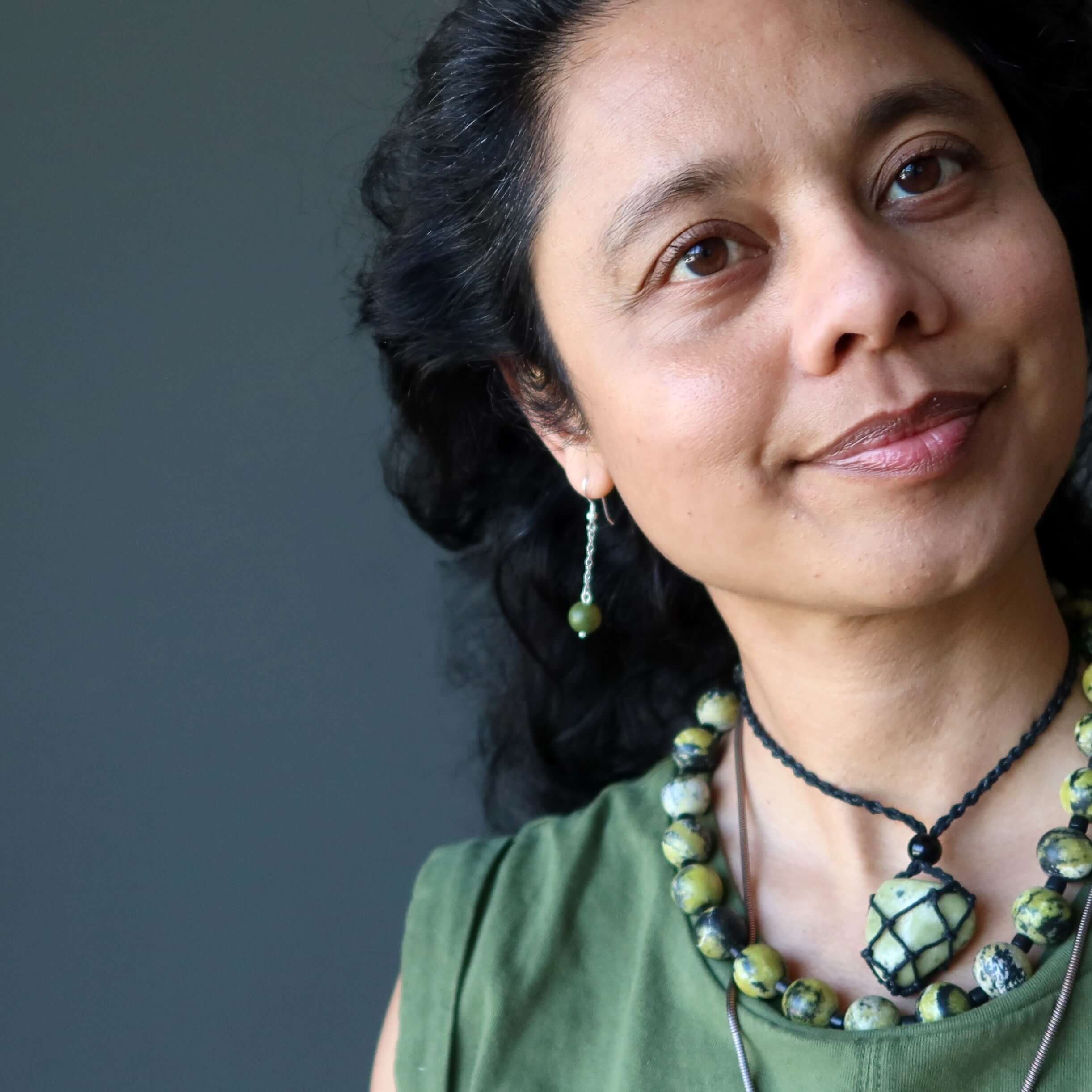 Woman wearing Serpentine earrings and matching green gemstone necklace on sterling silver chain