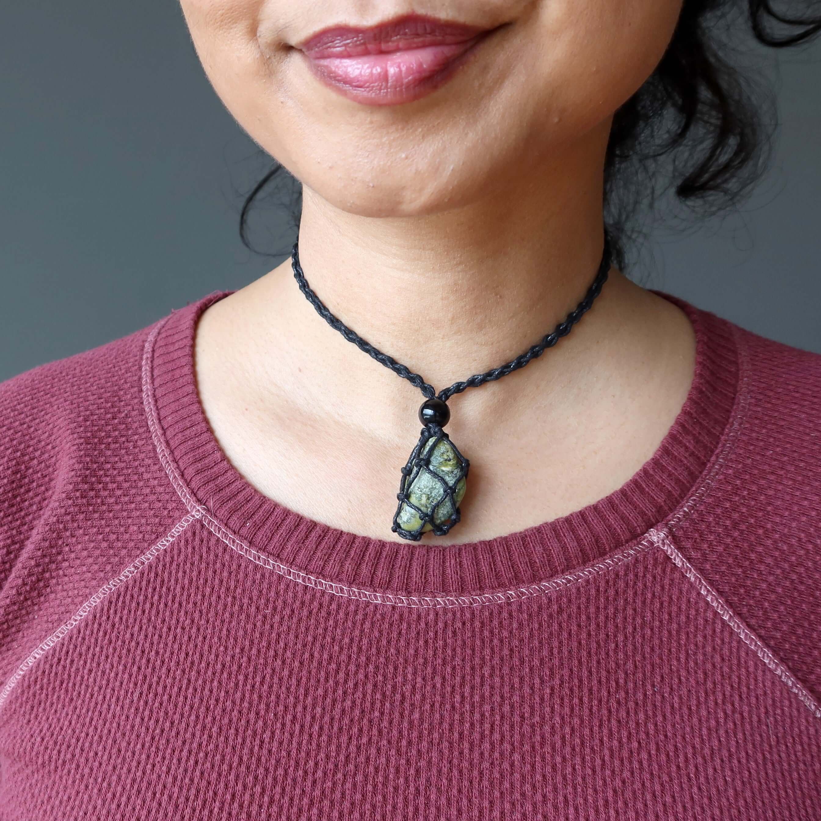 Woman wearing Serpentine macrame necklace with green transformation stone close to heart